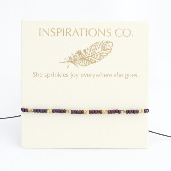 Bracelet with beaded design on a card featuring 'Inspirations Co.' and a feather illustration.