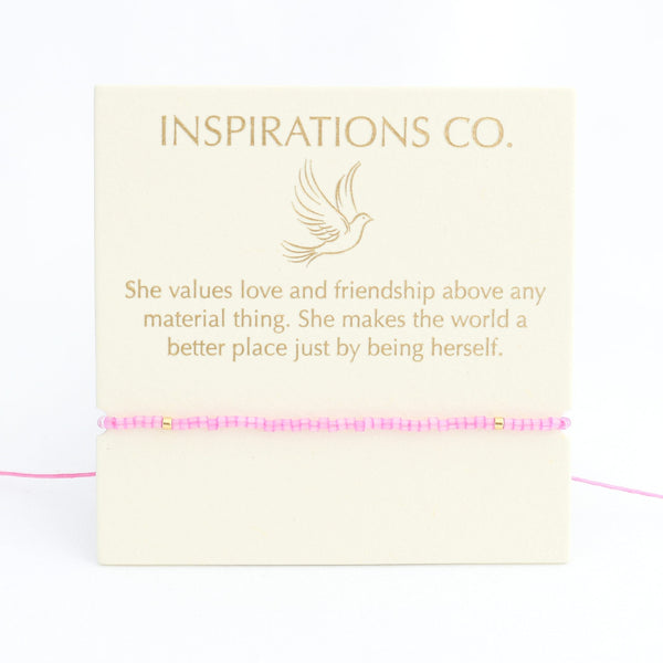 Bracelet with pink beads on a card from Inspirations Co. featuring a quote.