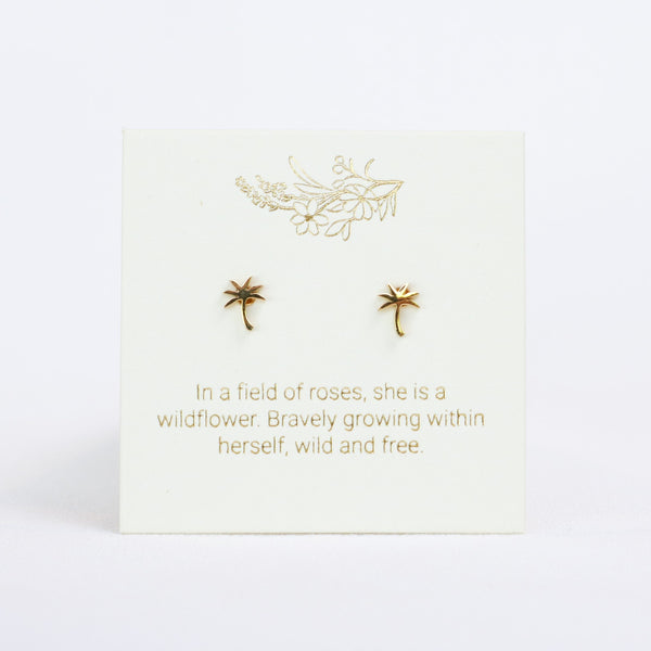 Gold earrings on a white card with gold text