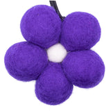 Purple felt balls arranged in a circular pattern on a white background