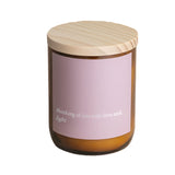 Candle with a wooden lid on a wooden surface