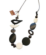 Necklace with black, brown, and white beads on a white fabric background