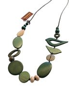 Necklace with green and brown beads on a white fabric background