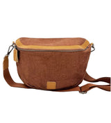 A brown saddle bag with a vegan leather trim, displayed against a plain background.