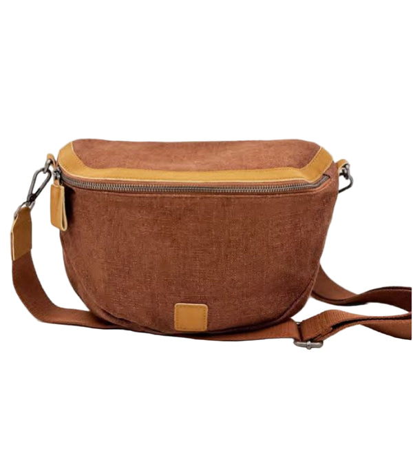 A brown saddle bag with a vegan leather trim, displayed against a plain background.