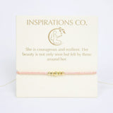 Pink bracelet with gold accents on a card from Inspirations Co.