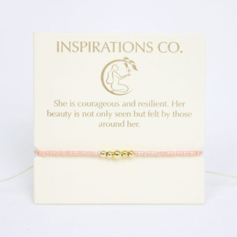 Pink bracelet with gold accents on a card from Inspirations Co.