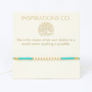 Bracelet with turquoise and gold beads on a card with 'Inspirations Co.' text