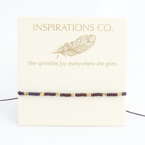 Bracelet with beaded design on a card featuring 'Inspirations Co.' and a feather illustration.
