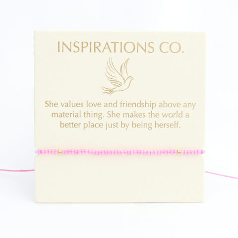 Bracelet with pink beads on a card from Inspirations Co. featuring a quote.