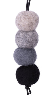 Four felted wool balls in black, gray, and beige on a white background