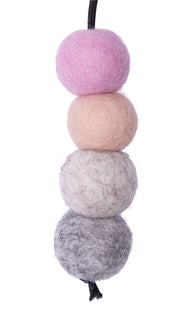 Set of four felted wool balls in gray, white, pink, and purple on a white background