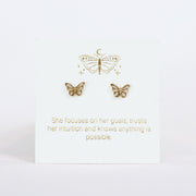 Gold butterfly earrings on a white card with motivational quote
