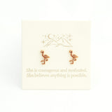 Gold flamingo earrings on a white card with motivational text