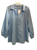 Light blue shirt on a hanger against a white background