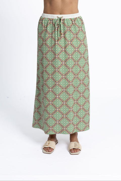 Green patterned skirt worn by a person on a white background