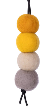 Set of four felted balls in gray, beige, yellow, and orange on a white background