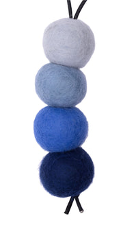 Four felted balls in blue, gray, and black on a white background