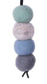 Four felted wool balls in gray, blue, beige, and green on a white background