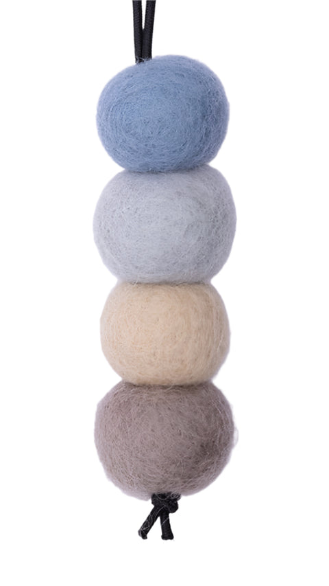 Four felted balls in gray, beige, and blue on a white background