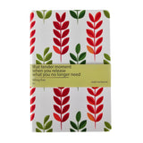 Notebook with red and green leaf pattern and motivational quote on a white background
