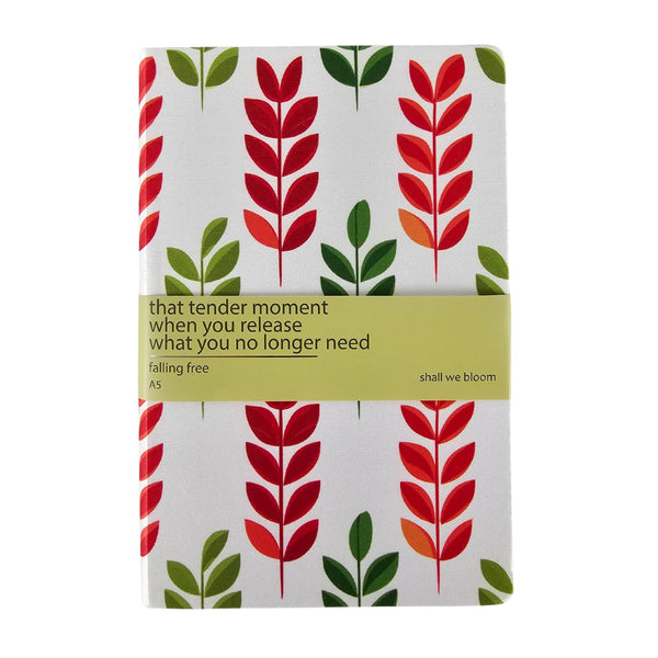 Notebook with red and green leaf pattern and motivational quote on a white background