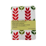 Notebook with red and green leaf pattern and motivational quote on a white background