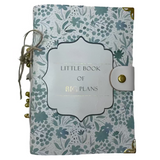 Notebook with floral design and 'Little Book of Big Plans' text on a textured surface