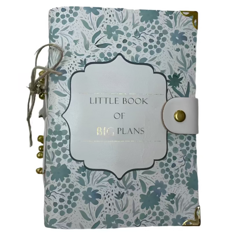 Notebook with floral design and 'Little Book of Big Plans' text on a textured surface