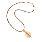Gold necklace with a leaf-shaped pendant on a white background