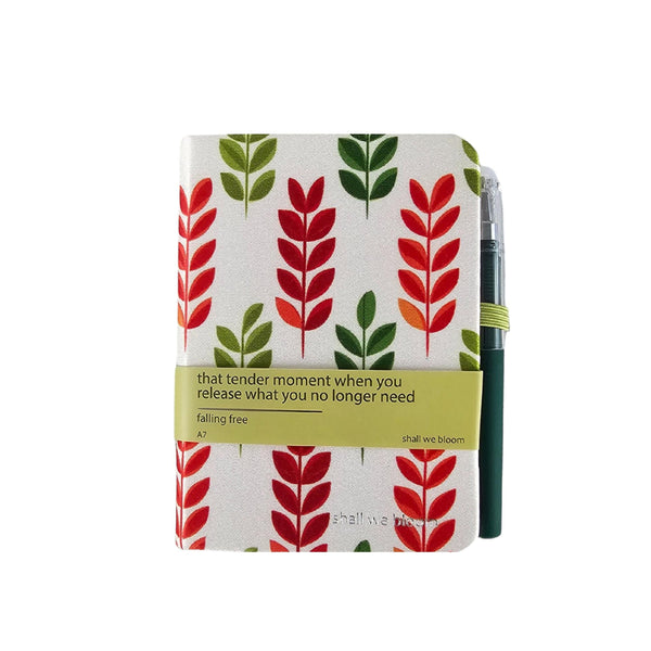 Notebook with red and green leaf pattern on a white background