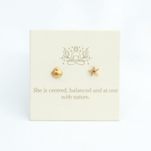 Gold shell and starfish earrings on a card with text and symbols.