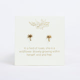 Gold earrings on a white card with gold text