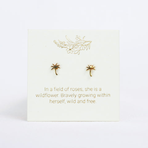 Gold earrings on a white card with gold text