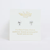 Silver earrings on a white card with gold text and design