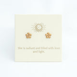 Gold flower earrings on a card with motivational text on a white background