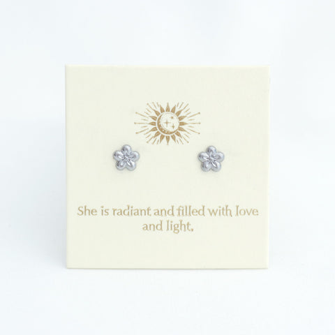 Flower-shaped earrings on a card with motivational text and logo.
