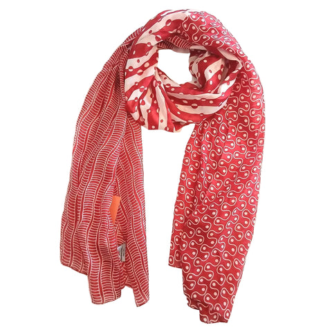 Red patterned scarf draped over a white surface