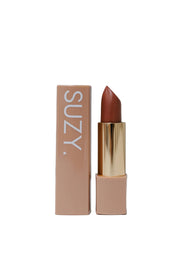 Lipstick with gold cap and 'SUZY' branding on a gray background